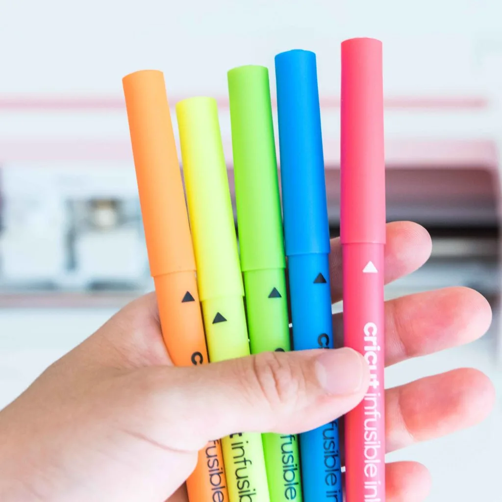 Holding Cricut Infusible Ink Neon Pens