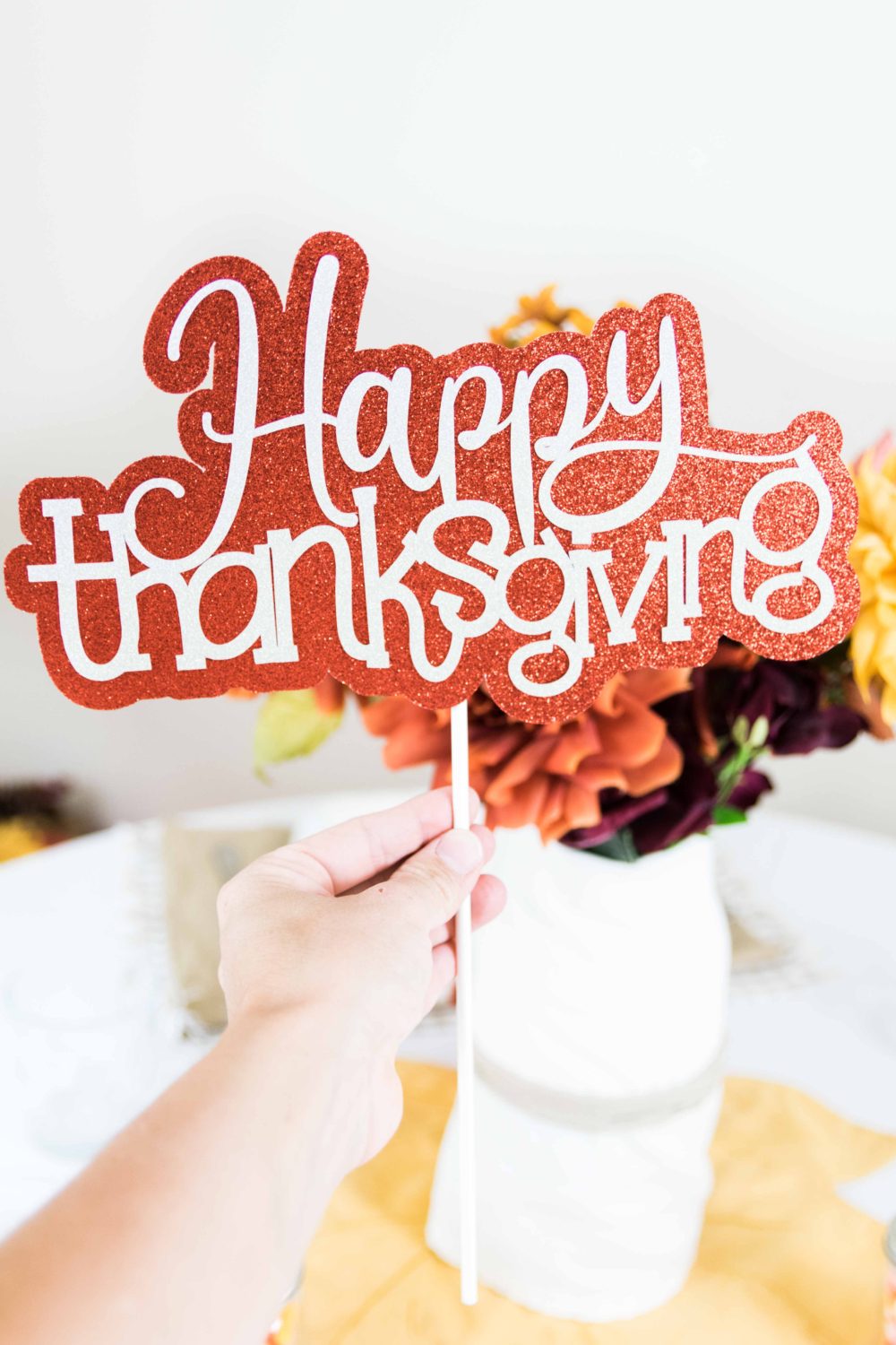 holding a happy thanksgiving cake topper 