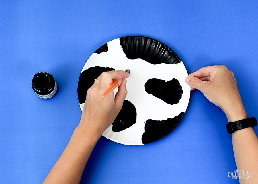 painting cow spots on cow paper plate craft