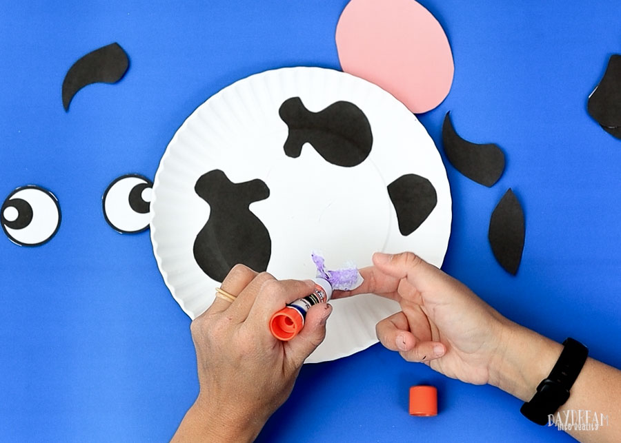 glue cow pieces on paper plate 